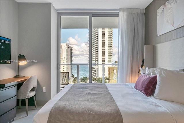 bedroom with a wall of windows and a water view