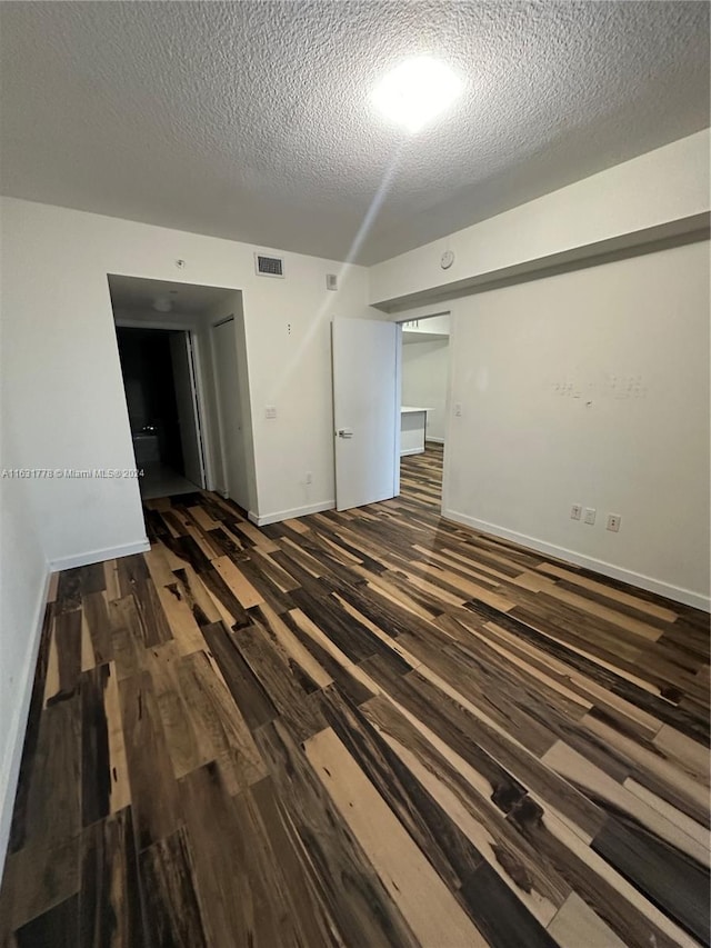 unfurnished room with a textured ceiling and hardwood / wood-style floors