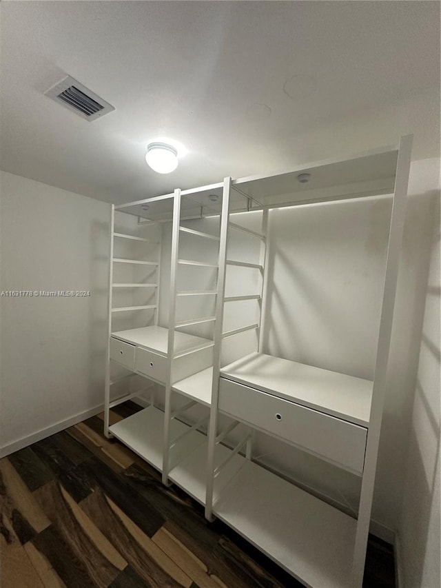 walk in closet with dark hardwood / wood-style floors