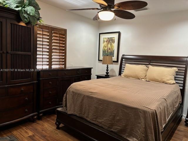 bedroom with dark hardwood / wood-style floors and ceiling fan