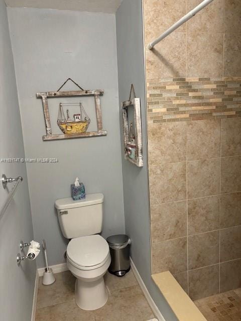 bathroom featuring tiled shower, toilet, and tile patterned floors