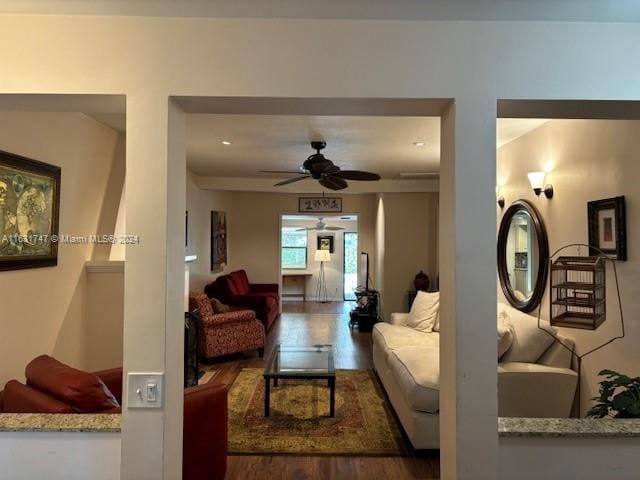 living room featuring dark wood-type flooring and ceiling fan