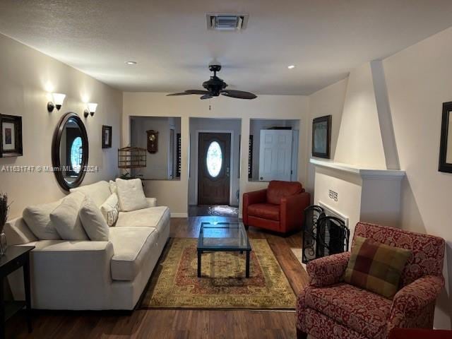 living room with ceiling fan and dark hardwood / wood-style flooring