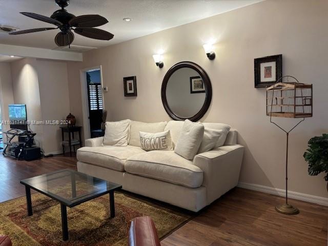 living room with ceiling fan and dark hardwood / wood-style flooring