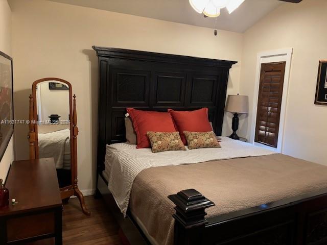 bedroom featuring dark wood-type flooring, ceiling fan, and vaulted ceiling