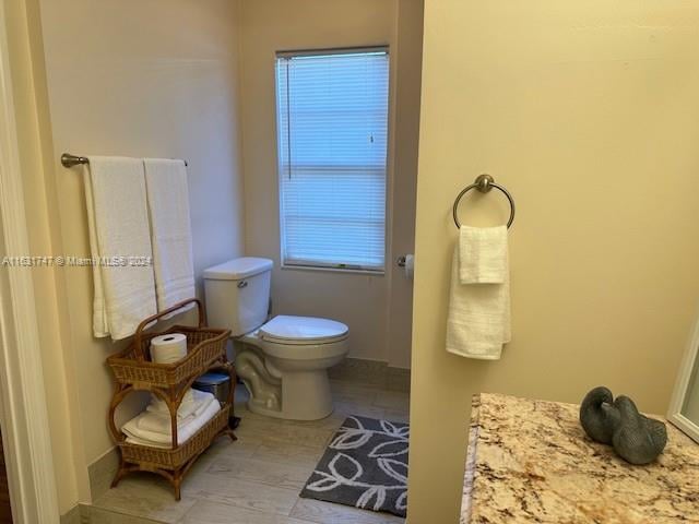 bathroom with toilet and hardwood / wood-style floors