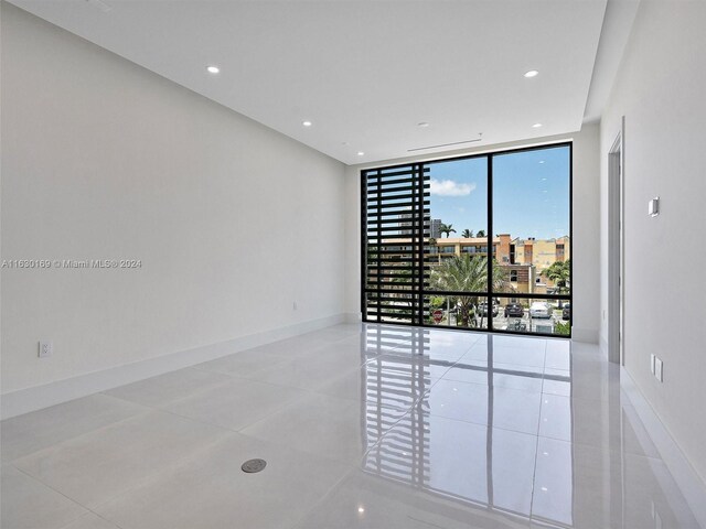 unfurnished room with a wall of windows