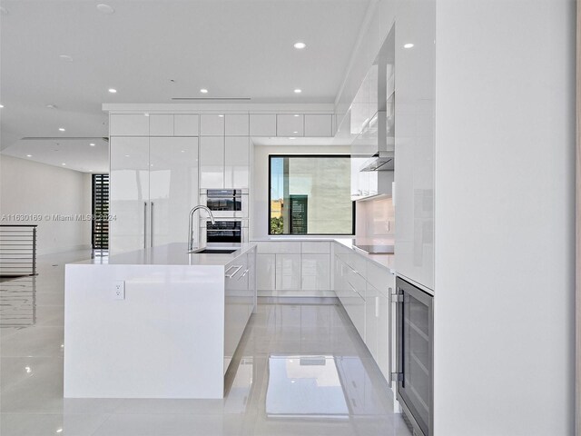 kitchen with white cabinetry, a large island, wine cooler, and black electric cooktop