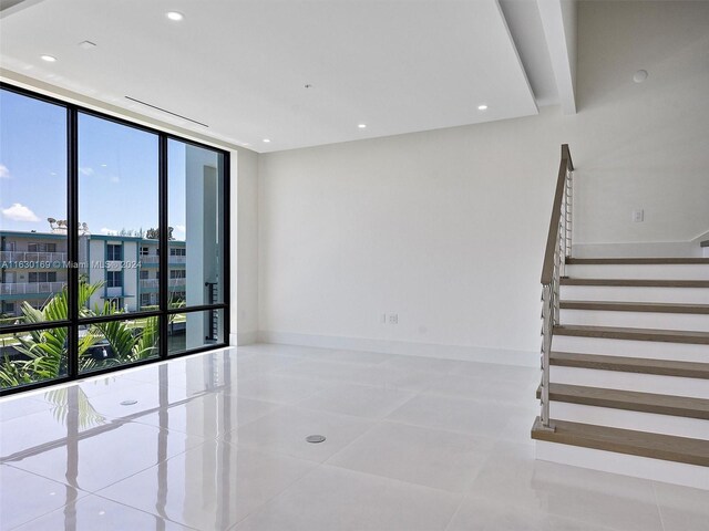 tiled empty room featuring expansive windows