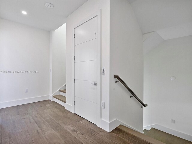 staircase with hardwood / wood-style flooring