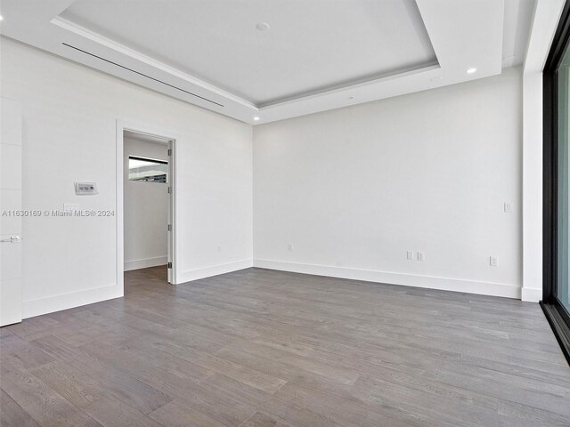 spare room with a raised ceiling and hardwood / wood-style flooring