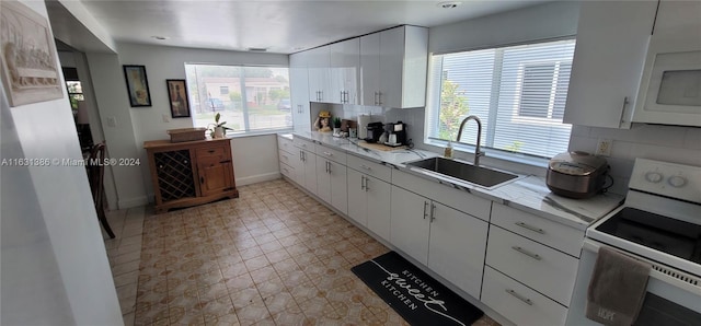 kitchen with a wealth of natural light, tasteful backsplash, and white appliances