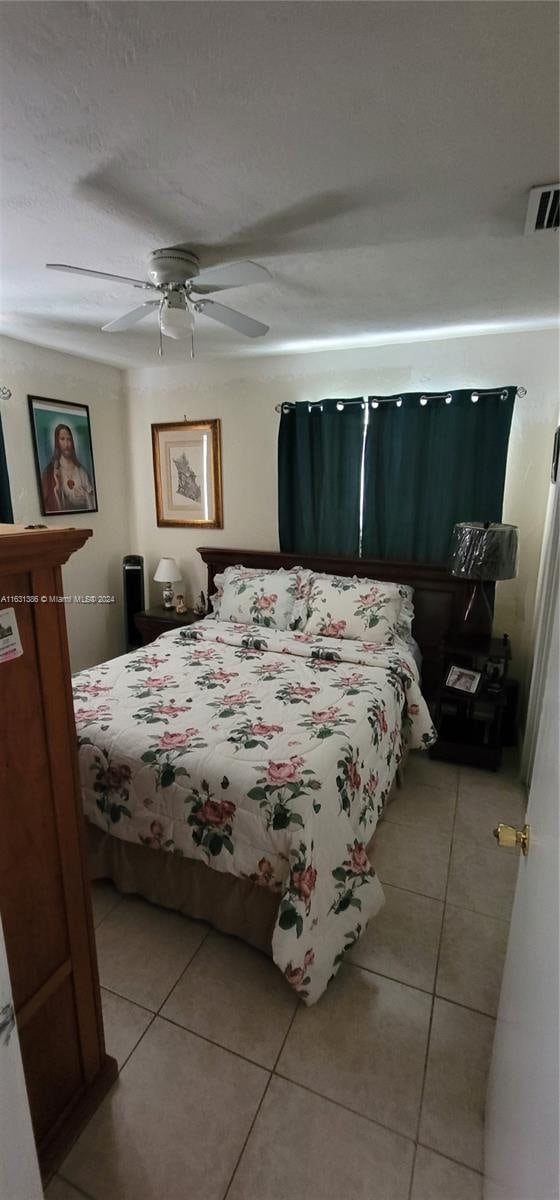 tiled bedroom featuring ceiling fan