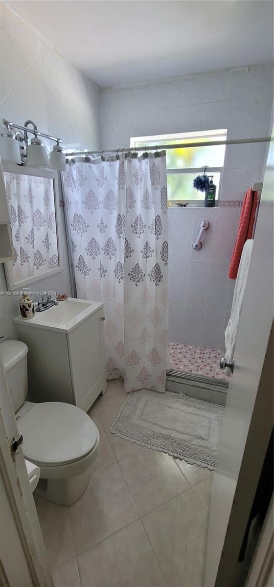 bathroom featuring tile patterned floors, toilet, vanity, and a shower with shower curtain