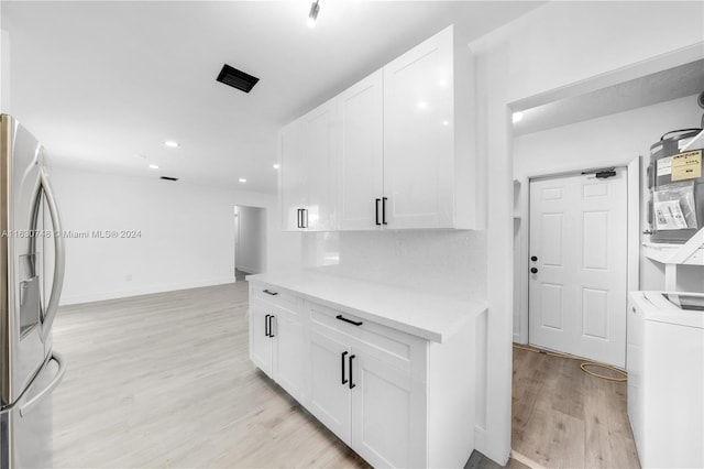 kitchen with light hardwood / wood-style flooring, white cabinets, tasteful backsplash, and stainless steel fridge with ice dispenser