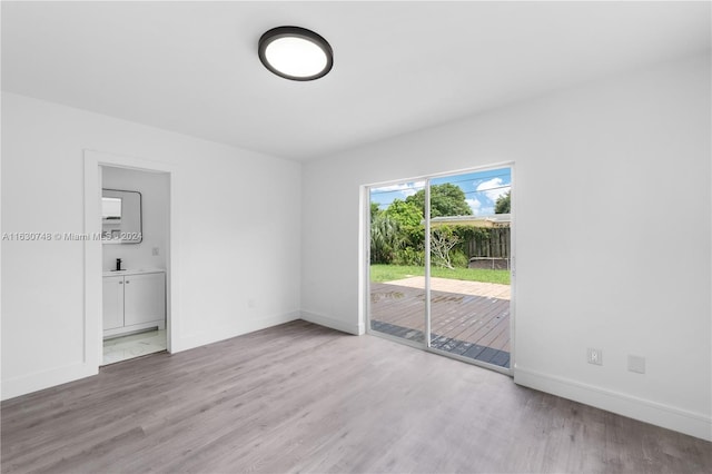 spare room with sink and wood-type flooring