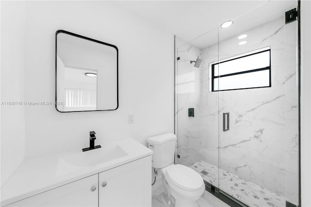 bathroom featuring vanity, an enclosed shower, and toilet