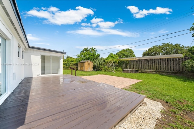 deck featuring a shed and a yard