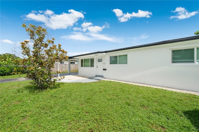 back of property with a patio and a lawn