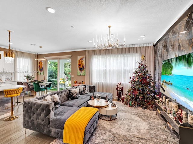 living room with crown molding, a textured ceiling, light hardwood / wood-style flooring, and a notable chandelier