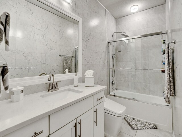 4414 Ficus St, Hollywood, FL 33021 - full bathroom with vanity, toilet, bath / shower combo with glass door, a textured ceiling, and tile patterned floors