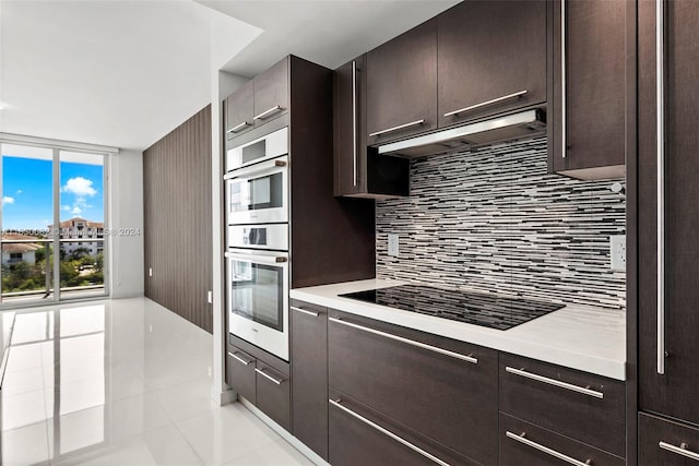 kitchen featuring light tile patterned floors, dark brown cabinetry, decorative backsplash, black electric cooktop, and stainless steel double oven