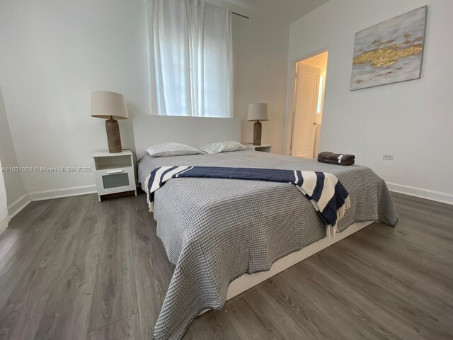 bedroom with dark hardwood / wood-style flooring