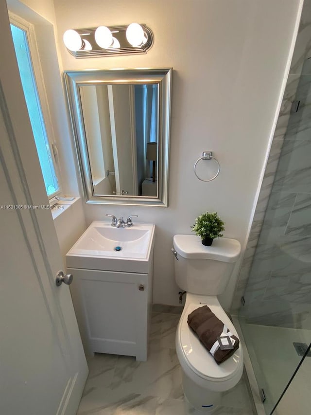 bathroom with vanity, a shower with shower door, and toilet