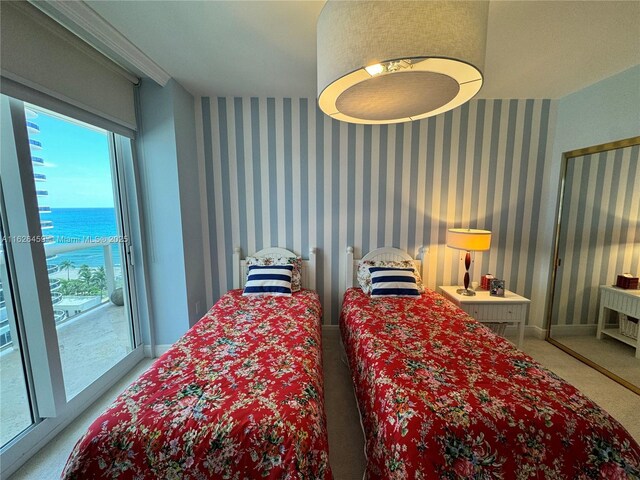 carpeted bedroom with multiple windows and a water view