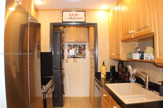 kitchen featuring stainless steel appliances, sink, tile walls, stacked washer / dryer, and light tile patterned flooring