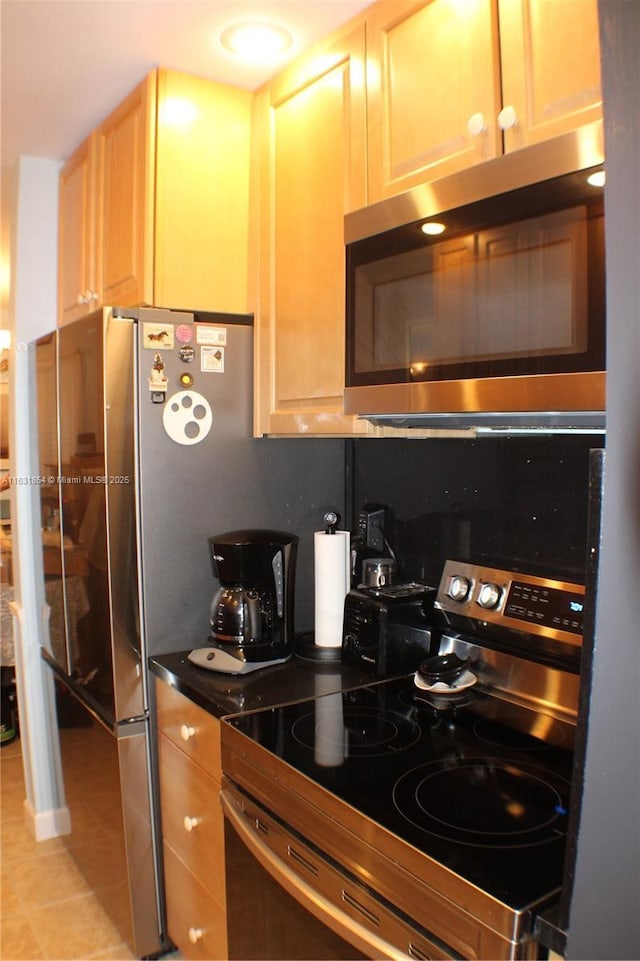 kitchen featuring backsplash, light tile patterned floors, stainless steel appliances, and light brown cabinetry