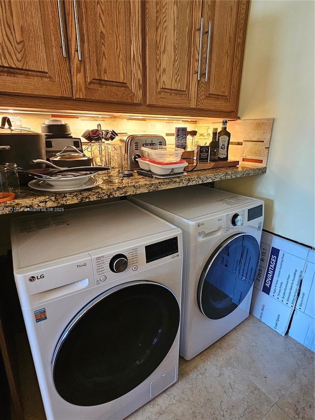 washroom with cabinets and washing machine and dryer