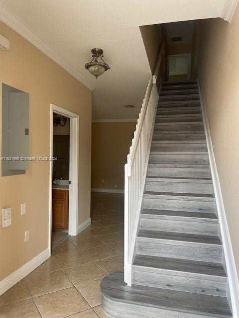 staircase featuring tile patterned floors and ornamental molding