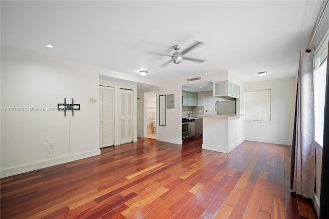 unfurnished living room featuring ceiling fan and hardwood / wood-style flooring