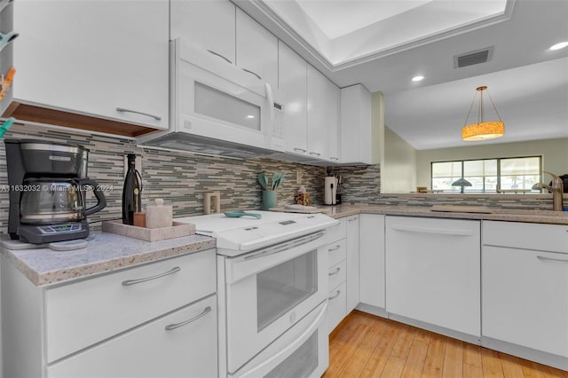 kitchen with white cabinetry, sink, backsplash, white appliances, and light wood-type flooring