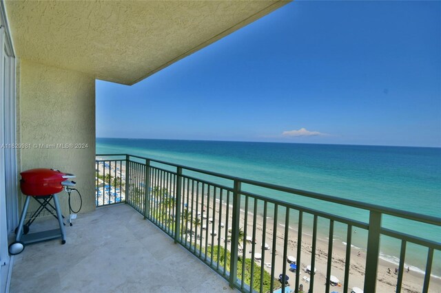 balcony featuring a water view and a view of the beach