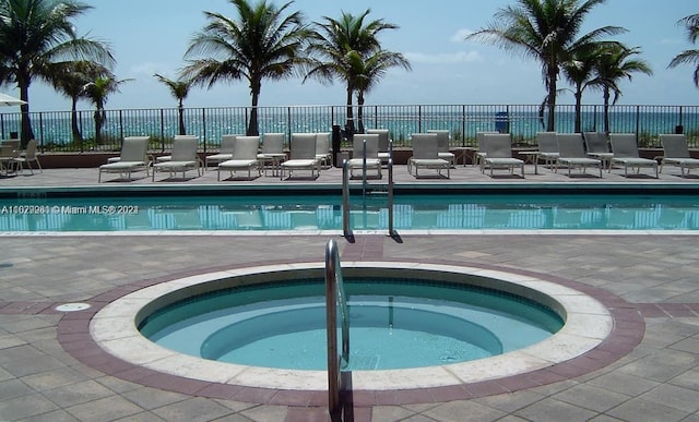 view of swimming pool featuring a patio area and a hot tub