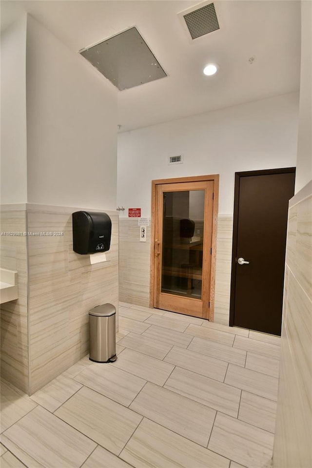 bathroom with tile patterned flooring and tile walls