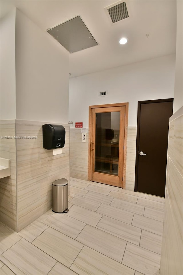 hallway featuring tile walls