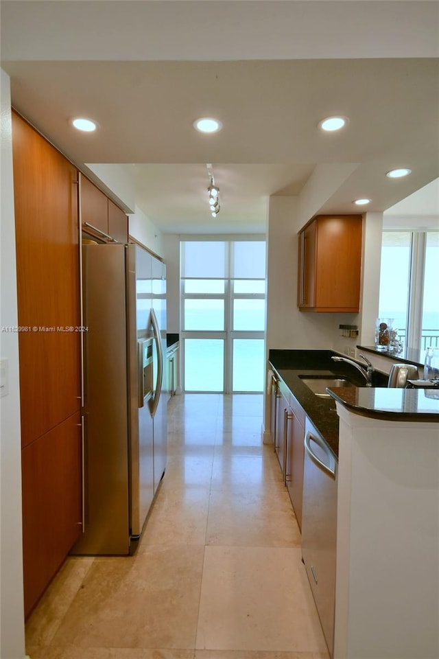 kitchen featuring kitchen peninsula, sink, light tile patterned floors, and stainless steel appliances