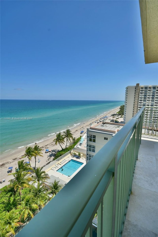 balcony featuring a view of the beach and a water view