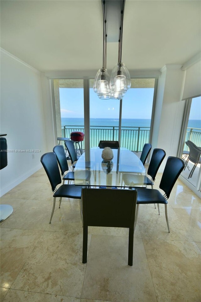 dining area featuring a water view, light tile patterned floors, and a chandelier