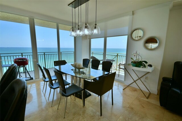 tiled dining area featuring a water view and a chandelier