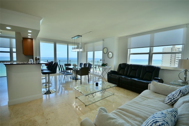 living room with ornamental molding, light tile patterned flooring, and a water view