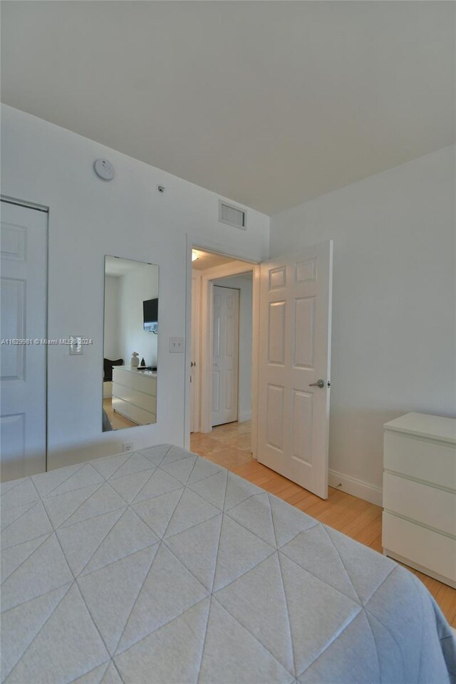 unfurnished bedroom with light hardwood / wood-style flooring and a closet