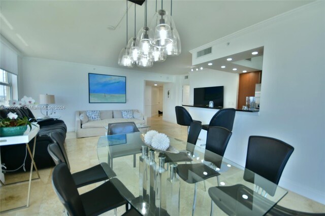 tiled dining space with a chandelier and crown molding