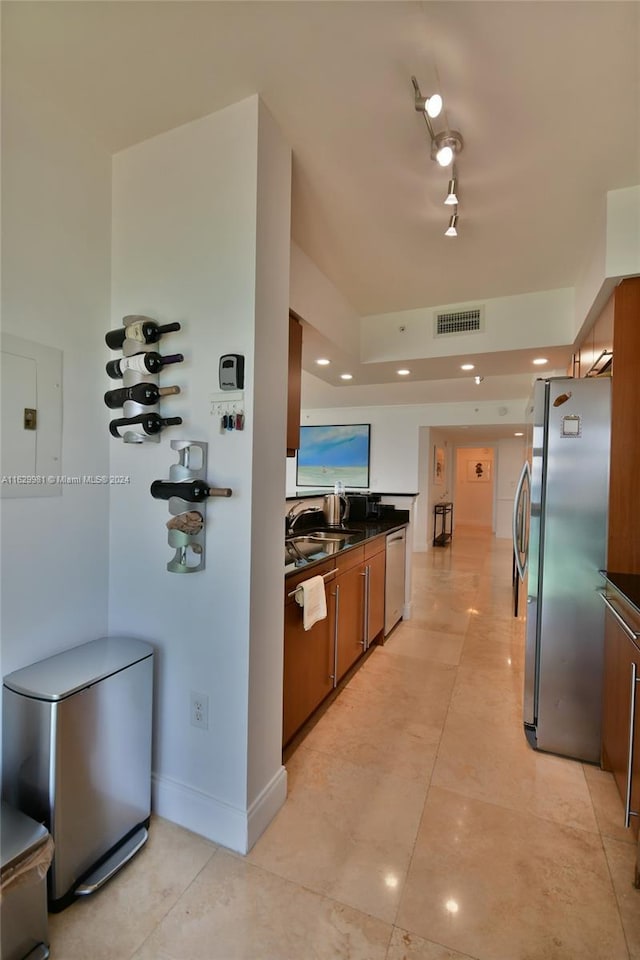 kitchen with light tile patterned floors, rail lighting, and stainless steel appliances