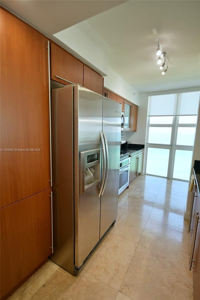 kitchen with track lighting and appliances with stainless steel finishes