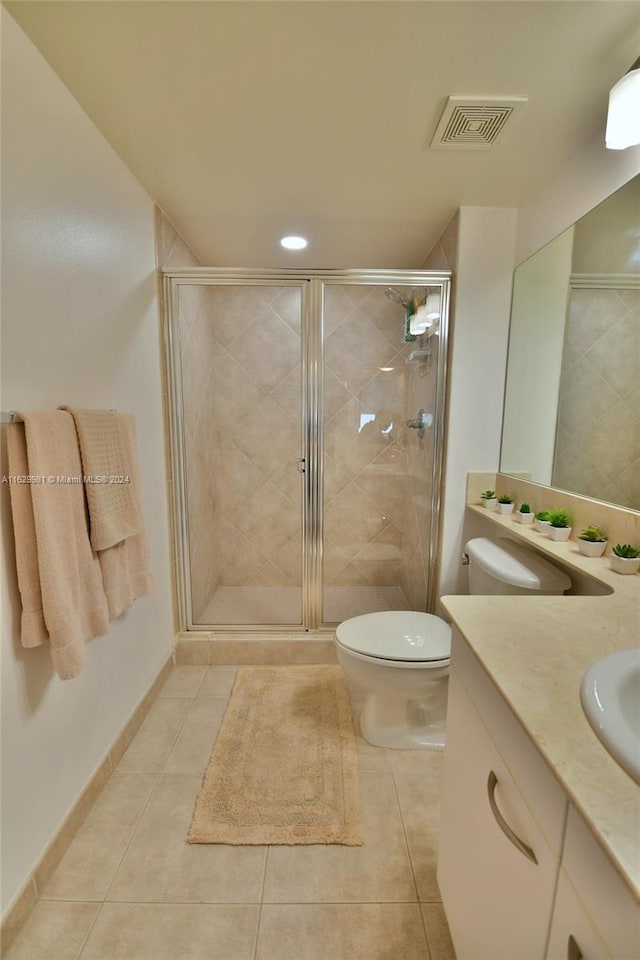 bathroom with walk in shower, vanity, toilet, and tile patterned flooring