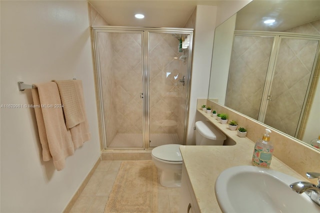 bathroom with vanity, toilet, a shower with shower door, and tile patterned flooring